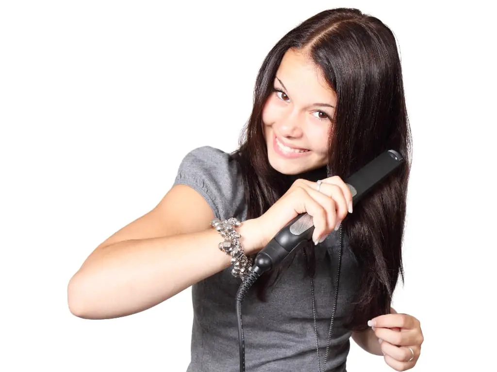 Lady using a titanium flat iron on her straight hair